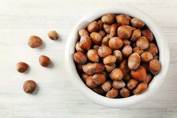 Hazelnuts in the bowl on white — Stock Photo, Image