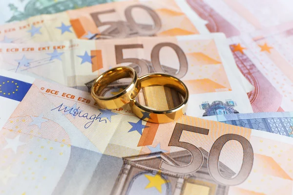 Golden wedding rings on banknotes — Stock Photo, Image