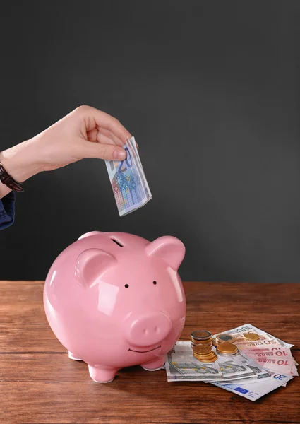 Mujer poniendo billete en euros — Foto de Stock