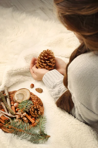 Vrouw met dennenappel en mand — Stockfoto