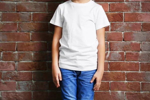 Kleiner Junge auf Ziegelmauer — Stockfoto