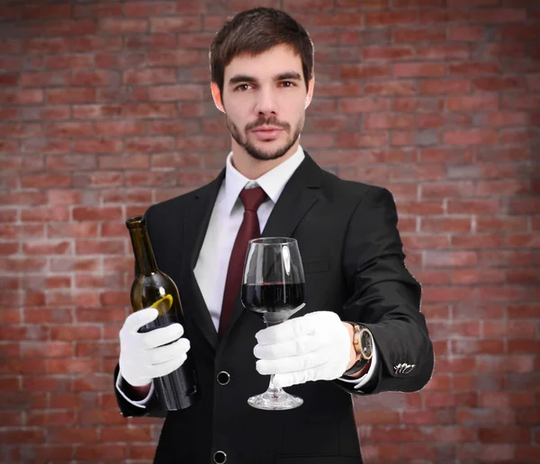 Homem segurando uma garrafa de vinho tinto — Fotografia de Stock