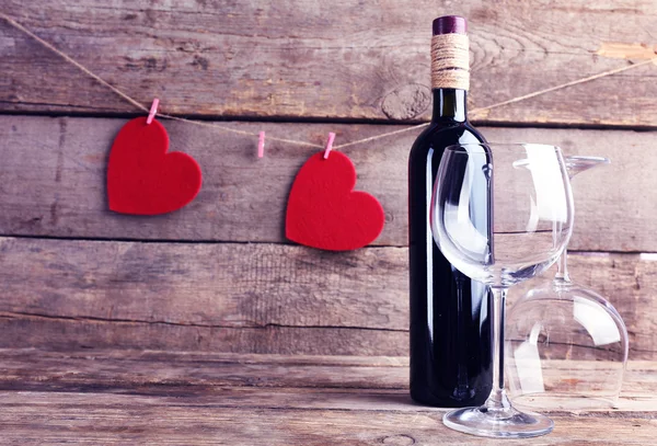 Cuori rossi con bottiglia di vino e bicchieri — Foto Stock