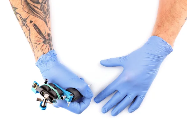 Руки татуировщика в синих перчатках — стоковое фото