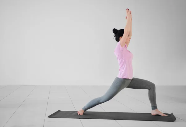 Vrouw doet yoga oefeningen in de sportschool — Stockfoto