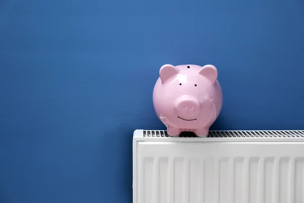 Piggy bank op radiator — Stockfoto