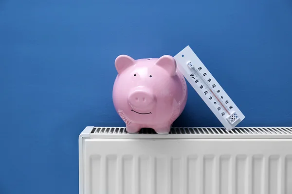 Piggy bank op radiator — Stockfoto