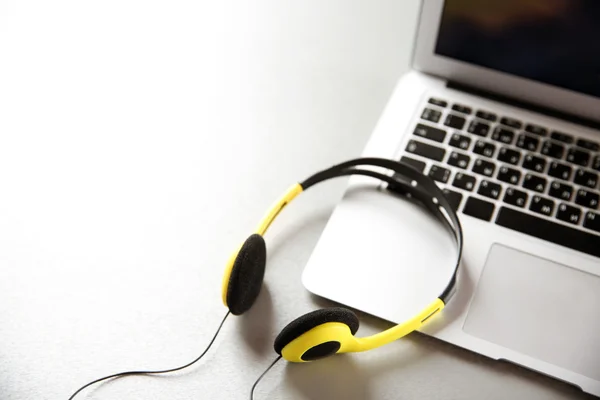 Fones de ouvido e laptop na mesa — Fotografia de Stock