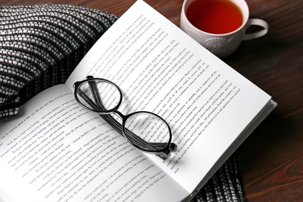 Ανοιχτό βιβλίο, φλιτζάνι τσάι και γυαλιά — Φωτογραφία Αρχείου