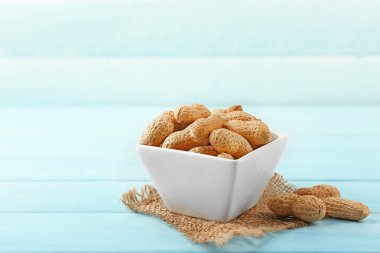 Mavi ahşap zemin üzerine kase fıstık