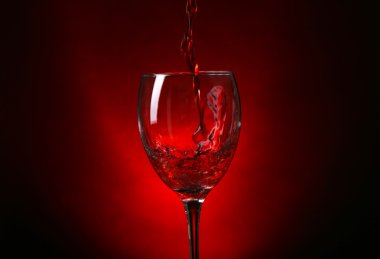 Cam koyu kırmızı zemin üzerine dökme şarap