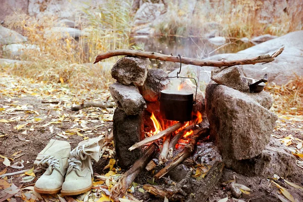 Kettle hanging above fire — Stock Photo, Image