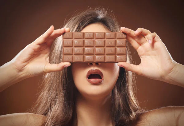 Morena cerrando los ojos con barra de chocolate —  Fotos de Stock