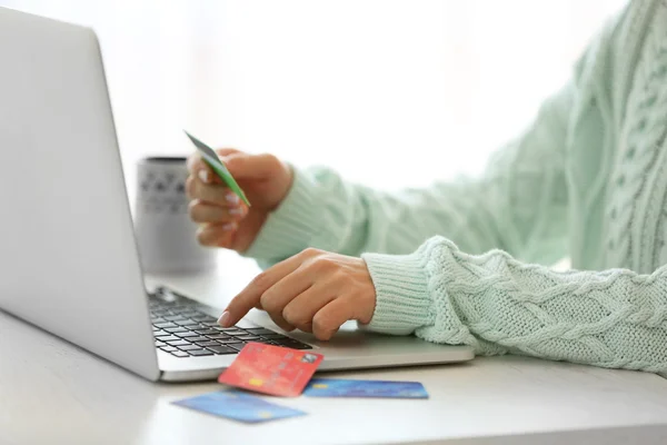 Concetto di commercio elettronico. Donna con carta di credito, laptop e tazza di caffè, primo piano — Foto Stock