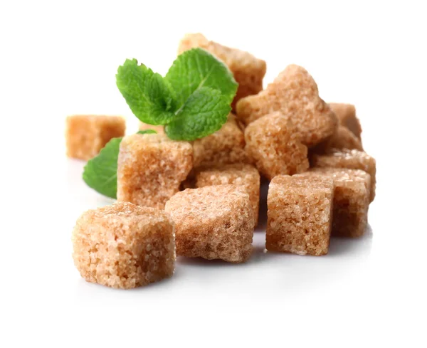 Haufen brauner Zuckerwürfel und Stevia isoliert auf weißem Hintergrund — Stockfoto