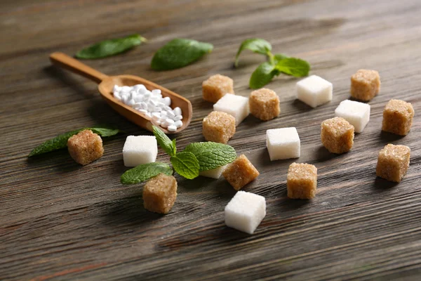 Cubos de azúcar y stevia sobre fondo de madera — Foto de Stock