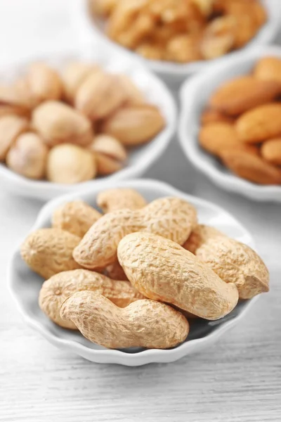 Cacahuetes, pistachos, almendras y nueces en los cuencos, primer plano —  Fotos de Stock