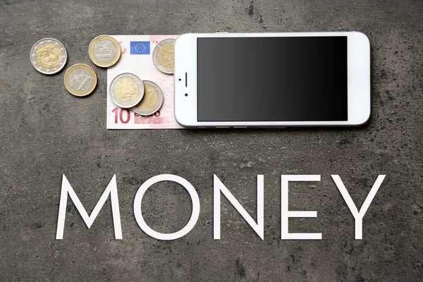 Смартфон с банкнотой евро и монетами — стоковое фото