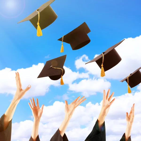 Les diplômés mains jetant chapeaux de graduation — Photo