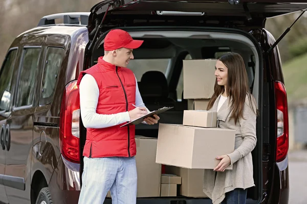 Delivery man and young woman Royalty Free Stock Images