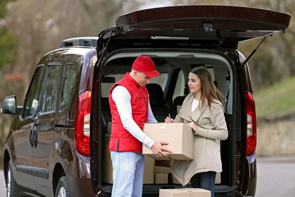 Delivery man and young woman Royalty Free Stock Photos