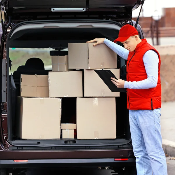 Delivery man standing near the car Stock Photo