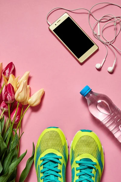 Buty Sportowe Telefon Komórkowy Słuchawkami Tulipanami Różowym Tle Przestrzeń Kopiowania — Zdjęcie stockowe