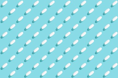 Açık mavi arka planda tıbbi haplar ve tabletlerle moda, kopyalama alanı. Yaratıcı tıp konsepti. Asgari düzeyde. Üst manzara, düz uzanma