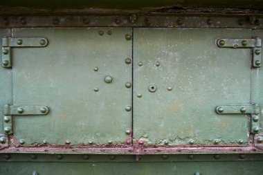 Cıvata ve perçinli soyut yeşil metal arka plan, kopyalama alanı. Eski boyanmış çelik dokular, askeri uçakların detayları. Ordu, savaş konsepti. Üst manzara, düz uzanma