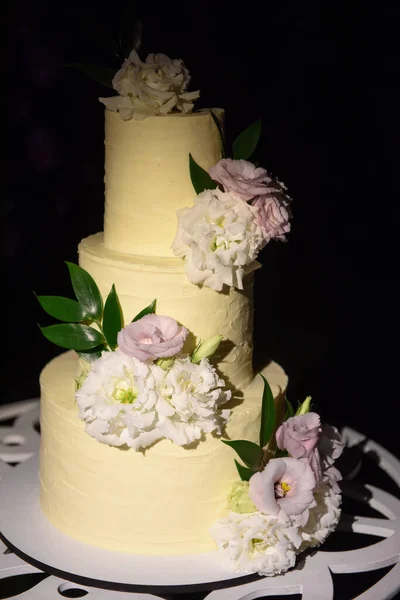 レストランのテーブルに新鮮な花で飾られたエレガントな3層の結婚式や誕生日ケーキ コピースペース 休日のコンセプト — ストック写真