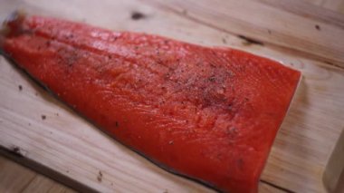 Ahşap masada tuzlu ve biberli çiğ somon..