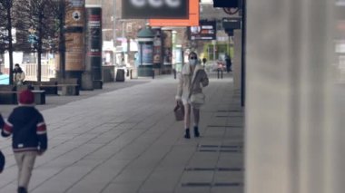 Varşova 'nın Eski Kasabası' nın sokaklarında yürüyen insanlar. Yüzlerinde maske olan insanlar.