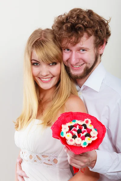 Pareja con flores de ramo de caramelos — Foto de Stock