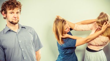 Aggressive mad women fighting over man.  clipart