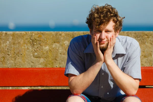 Tired exhausted man sitting on bench by sea ocean. — Stock Photo, Image