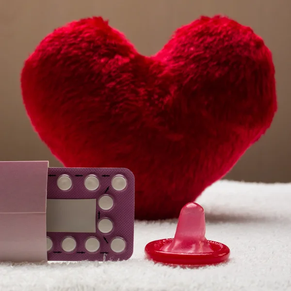 Doustne środki antykoncepcyjne pigułki prezerwatywy na czerwone serce — Zdjęcie stockowe