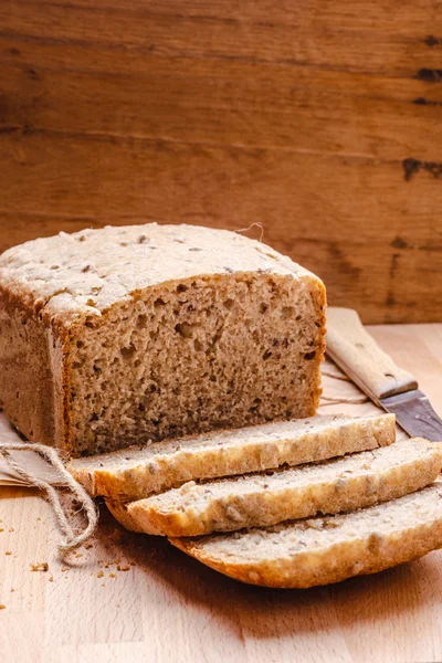 Kepekli ekmek kesme tahtası üzerinde dilimlenmiş — Stok fotoğraf