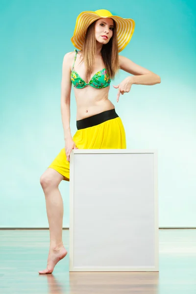 Woman in bikini holds blank presentation board. — Stock Photo, Image