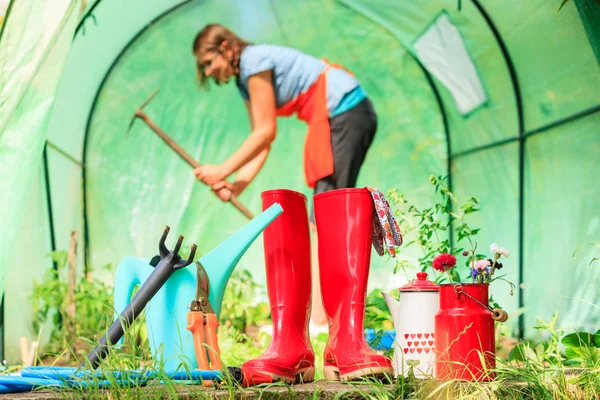 Perempuan petani dan alat berkebun di kebun — Stok Foto