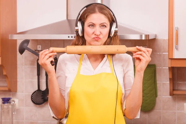 Dona de casa com fones de ouvido na cozinha — Fotografia de Stock