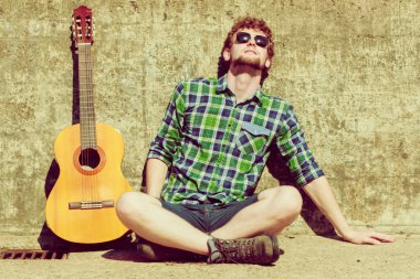 Genç hipster adam gitar ile açık sakallı.