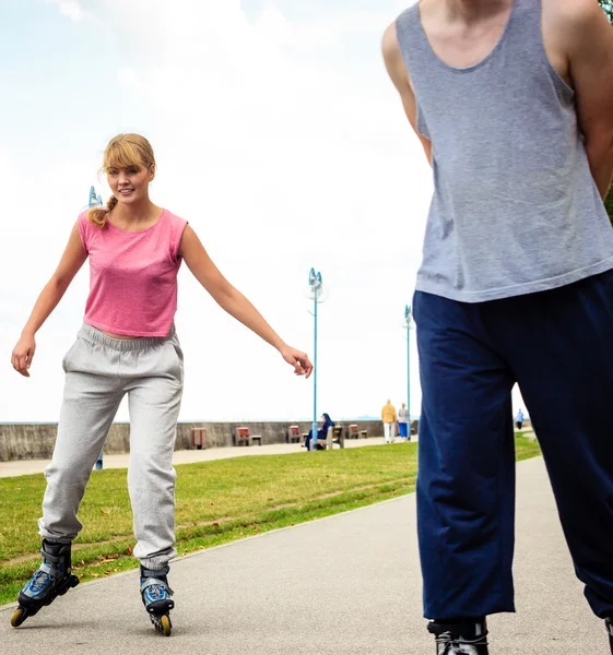 Pareja joven patinando en el parque — Foto de Stock