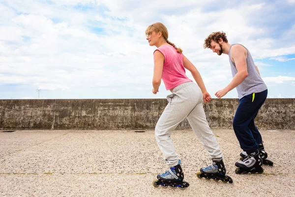 Pareja joven patinando en el parque — Foto de Stock