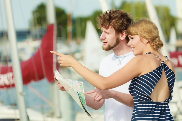 Туристическая пара в гавани смотрит вверх по карте — стоковое фото