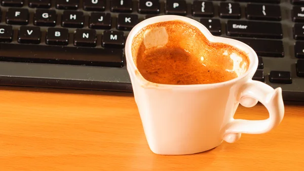 Xícara de café ao lado do teclado do computador . — Fotografia de Stock