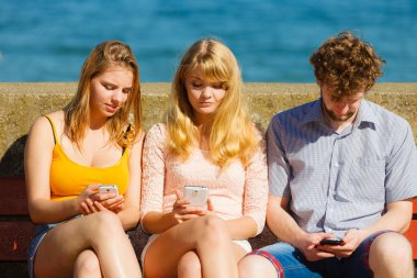 Arkadaşlar adam ve kadın cep telefonunu kullanarak.