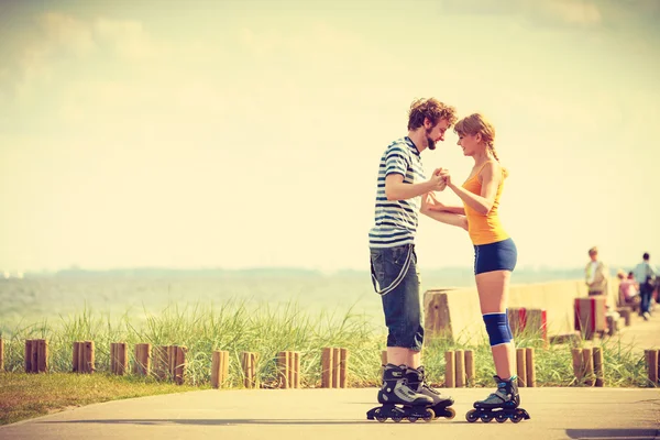 Jeune couple sur patins à roulettes chevauchant à l'extérieur — Photo