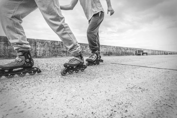 Due persone corrono insieme cavalcando pattini . — Foto Stock