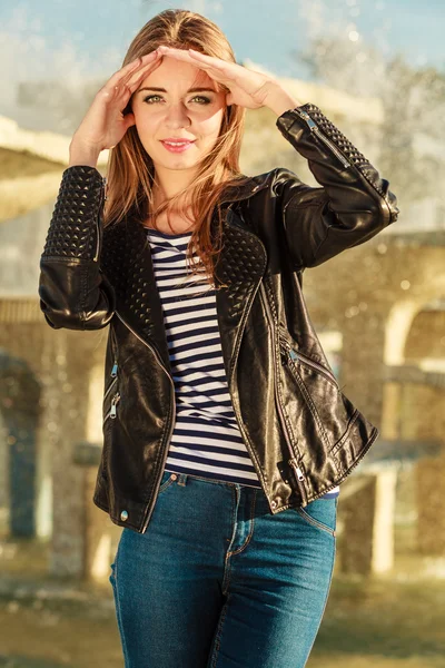 woman casual style posing against city fountain