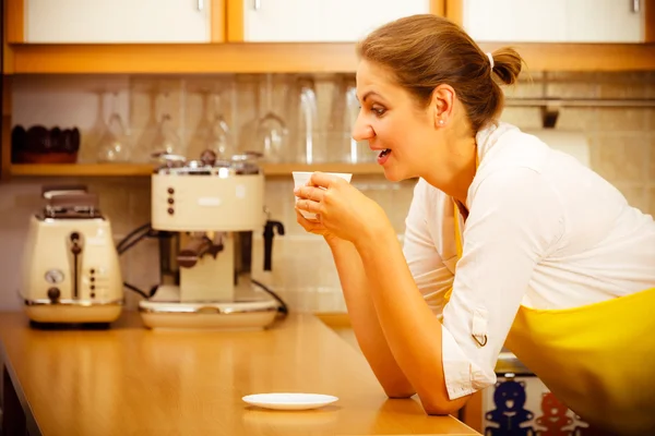 Зрелая женщина держит чашку кофе на кухне . — стоковое фото